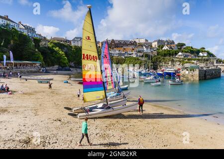 Katamarane mit farbenfrohen Segeln werden im historischen, malerischen Newquay Harbour in Newquay an der Küste von North Cornwall befahren. Stockfoto