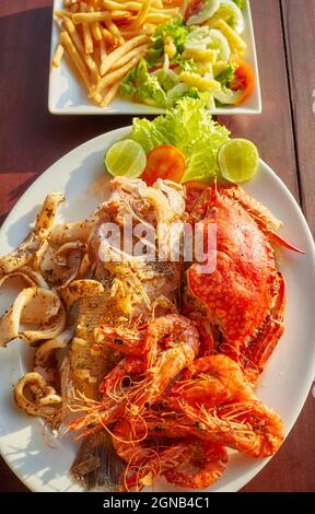Gegrillte Meeresfrüchte-Platte mit Krabben, Fisch, Garnelen und Tintenfisch mit Zitrone. Stockfoto