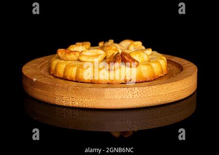 Ein ganz leckerer Plätzchen mit Erdnüssen auf Bambus-Untersetzer auf schwarzem Glas Stockfoto