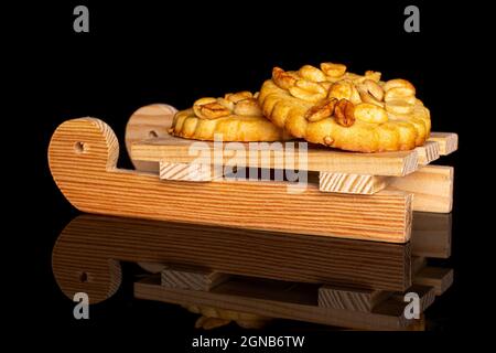Gruppe von zwei ganzen leckeren Keks mit Erdnüssen mit Holzschlitten auf schwarzem Glas Stockfoto