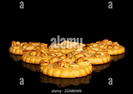 Gruppe von sechs ganzen leckeren Keks mit Erdnüssen auf schwarzem Glas Stockfoto