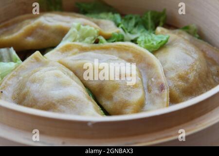 Gestreamte Gyoza (Jiaozi) in dampfenden Korb Bambus Stockfoto