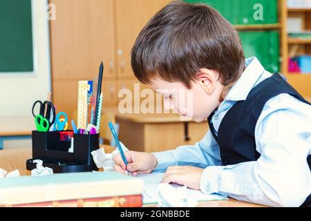 Ernsthafter Schuljunge im Klassenzimmer. Grundschüler. Zurück zur Schule. Stockfoto