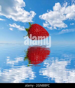 Erdbeere mit Himmel und Wolken Hintergrund, reflektiert auf Wasser Stockfoto