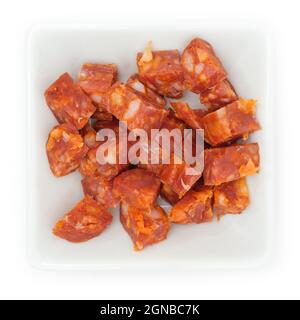 Nahaufnahme von gehackter Chorizo-Paprikawurst in einer weißen Schüssel, isoliert auf weißem Hintergrund Stockfoto