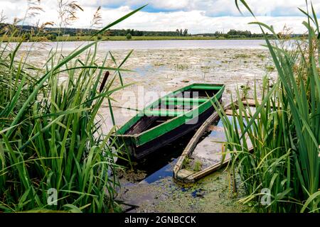 Ein altes Boot auf dem See an einem bewölkten Tag Stockfoto