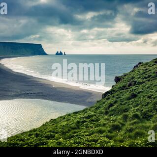 Dramatischer Sommermorgen im Dyrholaey Nature Reserve mit Blick auf den schwarzen und Reynisfjara Strand. Toller Blick auf die Klippen von Reynisdrangar in der Atla Stockfoto