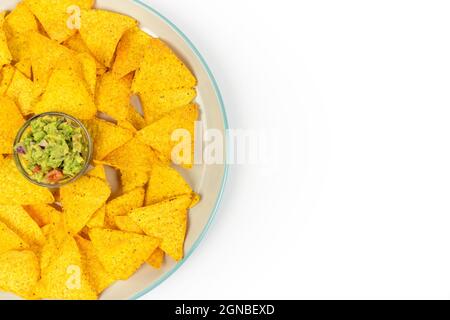 Ein großer Teller mit knusprigen Nachos und Guacamole-Chips in der Mitte der Schale auf einem weißen Teller mit Platz für Text. Draufsicht Stockfoto