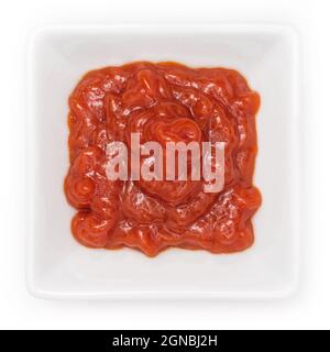 Nahaufnahme von rotem, frischem Tomatenketchup in einer Schüssel auf weißem Hintergrund Stockfoto