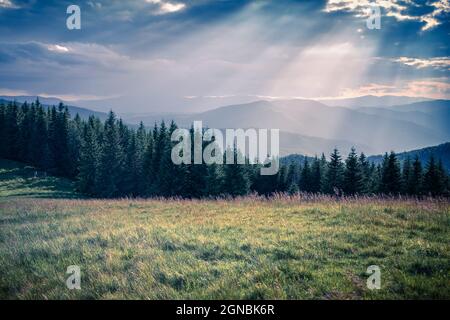 Letztes Sonnenlicht glühende Hügel und Wiesen in den Karpaten. Dramatische Abendszene auf dem Land. Ukraine, Europa. Indstagrasn Toning Fi Stockfoto