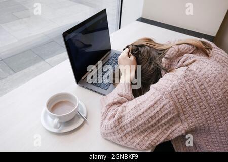 Müde junge Büroangestellte legte ihren Kopf auf den Schreibtisch. Burnout-Konzept für Büromitarbeiter. Arbeiten oder Ausbildung vom Coworking-Banner in der Draufsicht Stockfoto