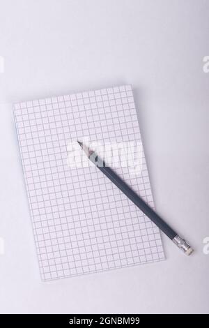 Bleistift und offenes Notizbuch auf weißem Hintergrund Stockfoto