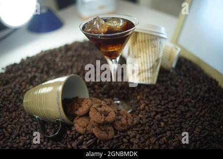 Eiskaffee-Cocktail im Martiniglas mit Schokoladenkeksen und gerösteten Kaffeebohnen Stockfoto