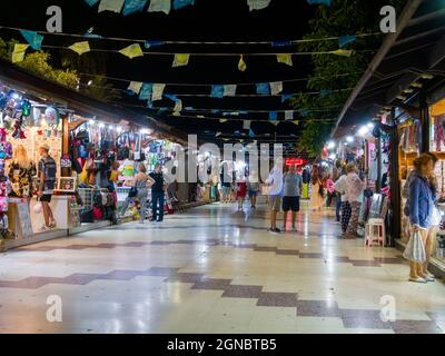 Leute, die nachts an den Marktständen an der Strandpromenade von Torrevieja an der Costa Blanca, Spanien, stöbern. Stockfoto