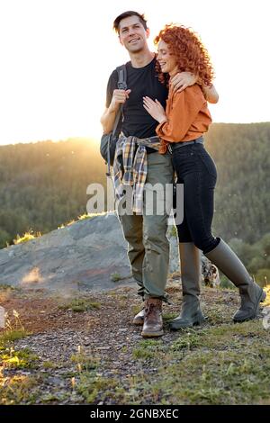 Mann und Frau auf dem Kopf der Berge in der Natur, zusammen reisen, lächeln, Glück fühlen beim Wandern, lässig gekleidet, Rotschopf Frau und Stockfoto