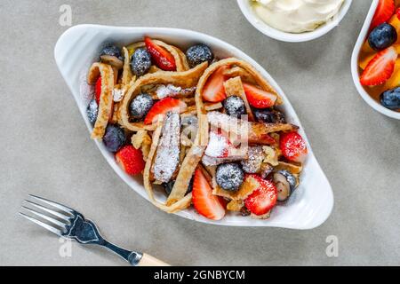 Pfannkuchenbänder mit frischen Sommerfrüchten - Erdbeeren und Heidelbeeren Stockfoto