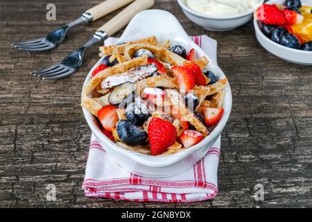 Pfannkuchenbänder mit frischen Sommerfrüchten - Erdbeeren und Heidelbeeren Stockfoto