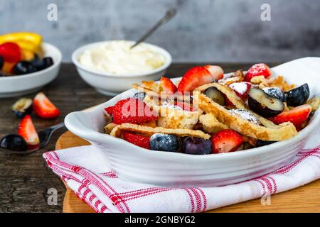 Pfannkuchenbänder mit frischen Sommerfrüchten - Erdbeeren und Heidelbeeren Stockfoto