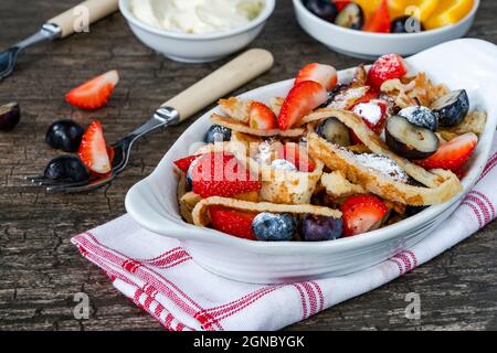 Pfannkuchenbänder mit frischen Sommerfrüchten - Erdbeeren und Heidelbeeren Stockfoto