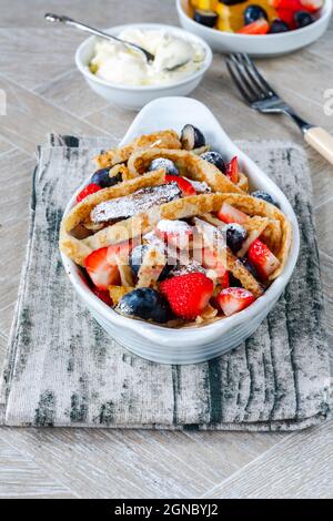 Pfannkuchenbänder mit frischen Sommerfrüchten - Erdbeeren und Heidelbeeren Stockfoto