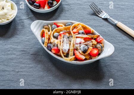 Pfannkuchenbänder mit frischen Sommerfrüchten - Erdbeeren und Heidelbeeren Stockfoto