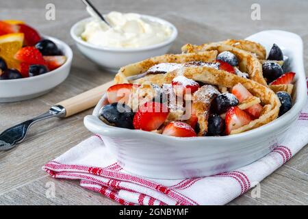 Pfannkuchenbänder mit frischen Sommerfrüchten - Erdbeeren und Heidelbeeren Stockfoto