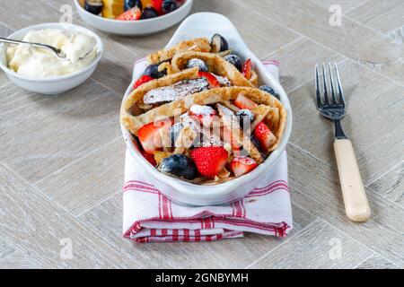 Pfannkuchenbänder mit frischen Sommerfrüchten - Erdbeeren und Heidelbeeren Stockfoto