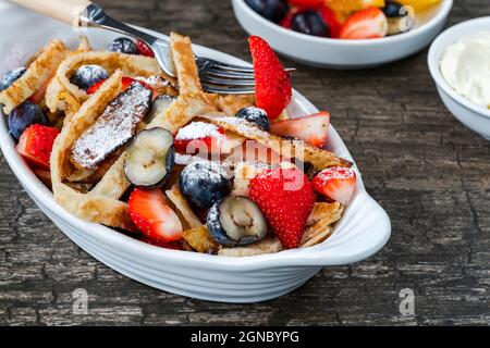 Pfannkuchenbänder mit frischen Sommerfrüchten - Erdbeeren und Heidelbeeren Stockfoto