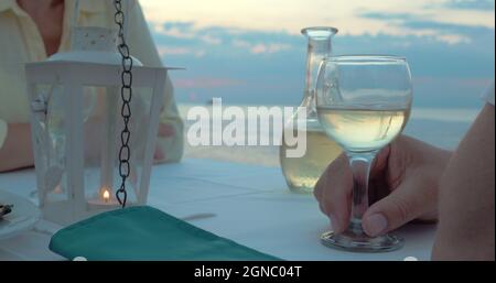 Paar toasten mit Wein im Strandrestaurant Stockfoto
