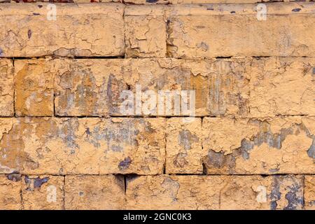 Abgeschälte alte orangene Farbe auf flacher, rauer Ziegelwand - Hintergrund und Struktur im Vollformat Stockfoto