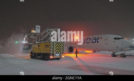 Enteisungsflugzeug flydubai Boeing 737-8 MAX in der Winternacht Stockfoto