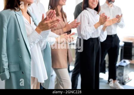 Nahaufnahme Business-Team klatscht die Hände, erfolgreiche Arbeit von jungen Männern und Frauen, in hellen modernen Büro. Schöne junge Damen und Herren in formeller Kleidung Stockfoto