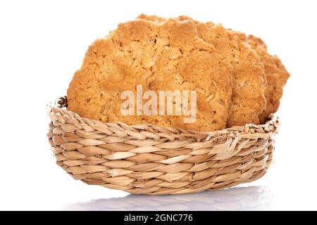 Mehrere leckere Torchetti-Kekse mit Haferflocken in einem Strohteller, Nahaufnahme, isoliert auf Weiß. Stockfoto