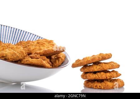 Mehrere leckere Torchetti-Kekse mit Haferflocken in einer Keramikplatte, Nahaufnahme, isoliert auf Weiß. Stockfoto