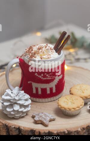 Weihnachten, eine Tasse heiße Schokolade oder Eierkuchen mit einem gestrickten Wraparound gemütlich und Hackfleisch. Stockfoto