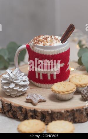 Weihnachten, eine Tasse heiße Schokolade oder Eierkuchen mit einem gestrickten Wraparound gemütlich und Hackfleisch. Stockfoto