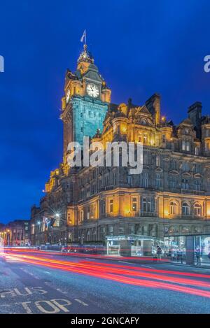 Der Uhrenturm des Balmoral Hotels wurde nachts beleuchtet, und unten verwischt die Ampel. Stockfoto