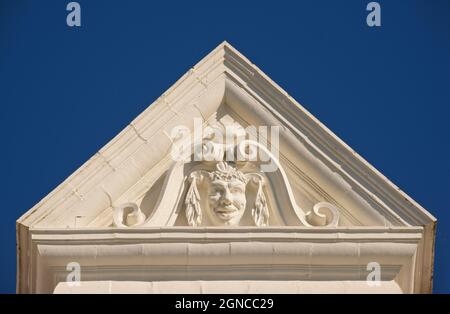 Detail der Dachdekoration. In einem viktorianischen Zeitalter am Meer Hotel am Fuße der West Street, Brighton. Einst roter Ziegel, jetzt weiß gestrichen. Neoklassische Skulptur. Stockfoto