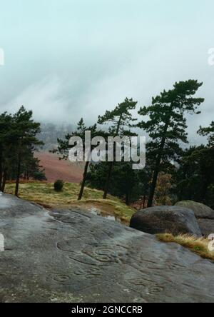 Sehen Sie sich die ungewöhnlichen prähistorischen Felskunstentwürfe nordwestlich am Ausbiss des Hangingstone Quarry Rock oberhalb von Ilkley, West Yorkshire, England, Großbritannien, an. Stockfoto