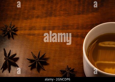 Detail einer Tasse Tee und etwas Sternanisgestein breitete sich auf dem Tisch aus. Stockfoto