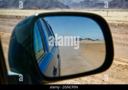 Blick im Spiegel: Auto auf der Straße C27 südlich von Sesriem, Wüste Namib, Bezirk, Region Hardap, Maltahöhe, Namibia Stockfoto