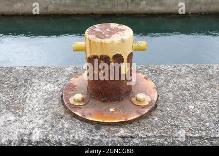 Ankerplatz Poller auf Zement am Hafen mit Wasser im Hintergrund. Hochwertige Fotos Stockfoto