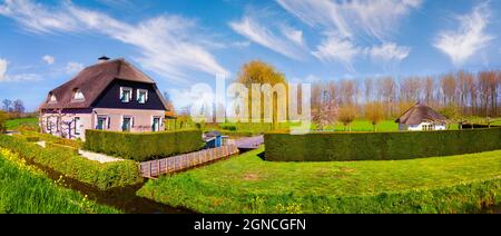 Sonniges Frühlingspanorama der typisch holländischen Landschaft. Farbenfrohe Morgenszene in der kleinen Stadt Alblasserdam, in der Nähe des berühmten Windmühlenmuseums - Stockfoto