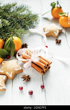 Weihnachts- und Neujahr-Karte mit Tannenzweigen, Mandarinen, Zimt und Ingwerkekse. Stockfoto