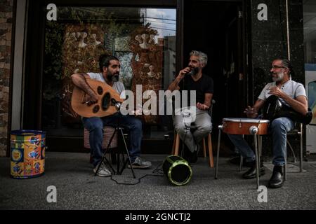 Beirut, Libanon. September 2021. Eine Gruppe Libanesen singen auf einem Straßenbelag vor ihrem Geschäft während eines Stromausfalls. Quelle: Marwan Naamani/dpa/Alamy Live News Stockfoto