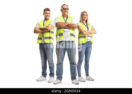 In voller Länge Porträt von zwei Männern und einer Frau, die eine reflektierende Sicherheitsweste trägt und mit gekreuzten Armen auf weißem Hintergrund isoliert posiert Stockfoto