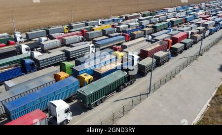 Lange Schlange auf dem Parkplatz für Lastwagen. Logistik. Export von landwirtschaftlichen Erzeugnissen Stockfoto