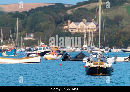 Niedriger Blick über Salcombe Harbour in Richtung East Portlemouth und große Villa mit Blick auf den Hafen, aufgenommen bei Sonnenuntergang in der goldenen Stunde, Yachten im Blick Stockfoto