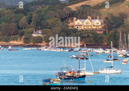 Sonnenuntergang über dem Hafen von Salcombe, der ein fabelhaftes Licht über dem Fluss Ria in Richtung Ost-Portlemouth wirft, mit vielen Yachten, die im Hafen festgemacht sind. Stockfoto