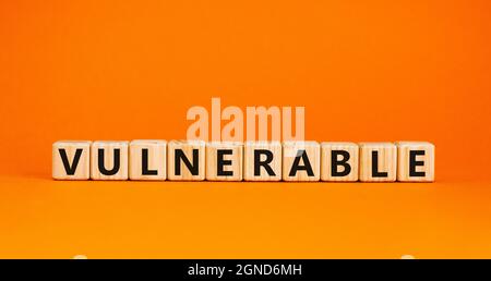 Anfälliger Symbol. Das Wort verwundbar auf Holzwürfeln. Schöner orangefarbener Tisch, orangefarbener Hintergrund. Business und Vulnerable Concept. Speicherplatz kopieren. Stockfoto